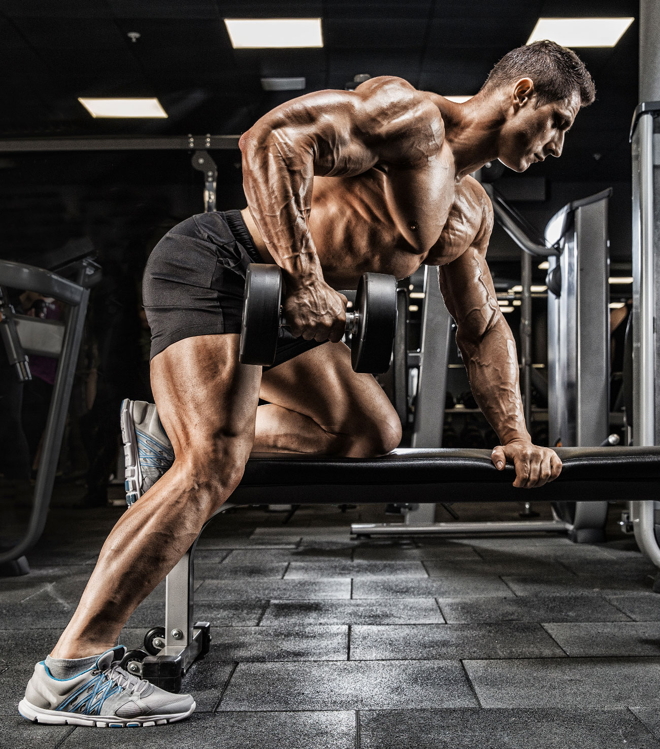 Muscular Guy Doing Dumbbell Rows in Black Shorts